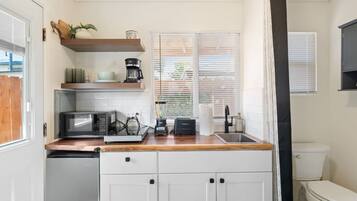 A compact kitchen with a microwave, toaster, and coffee maker.