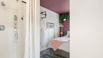 Een badkamer met een douchecabine van glas, een witte handdoekhouder en een douchekop.