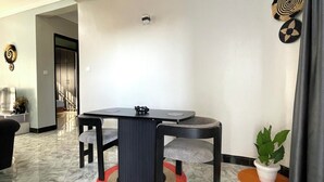 Un coin repas avec une table ronde, des chaises et une plante en pot.