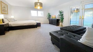 A bedroom with a bed, a sofa, a dresser, and a large window. - LUX 7BR/4BA Villa w/Heated Pool, next to the Strip (Las Vegas)