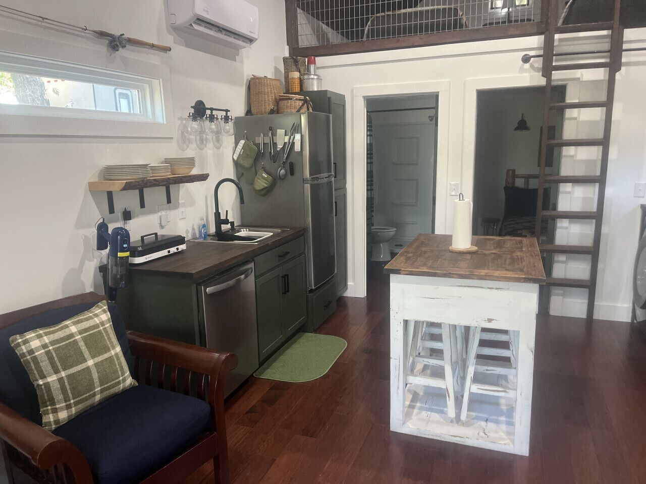 Une cuisine compacte avec une table à manger en bois, un évier encastré et un petit îlot central.