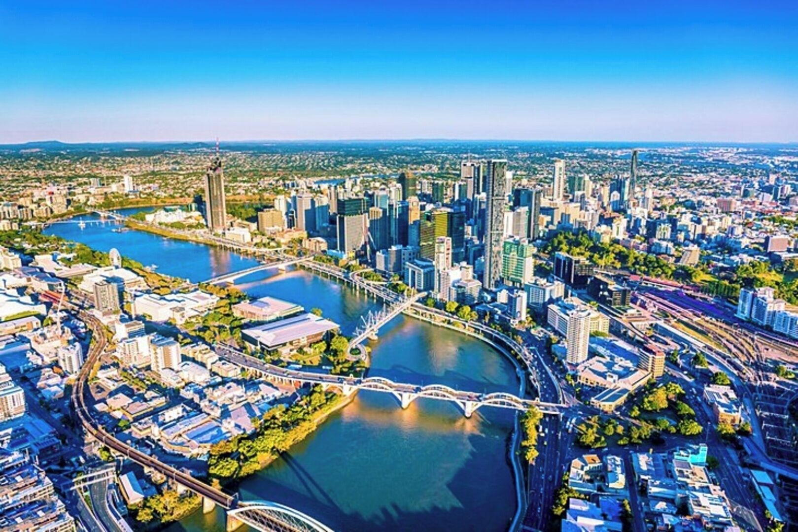 A cityscape with a river, bridges, and high-rise buildings.