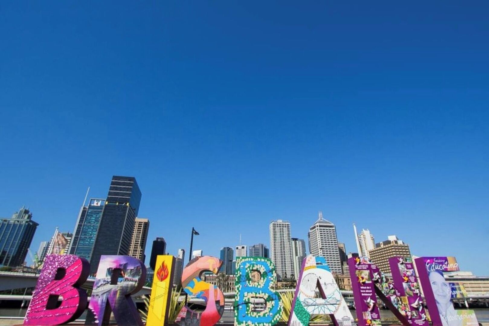 A city skyline with the word 'BRISBANE' spelled out in colorful letters.