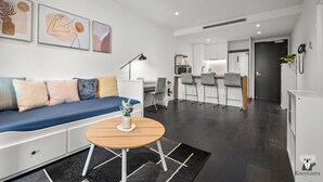 Een moderne woonkamer met een bank, een salontafel en kunst aan de muur.