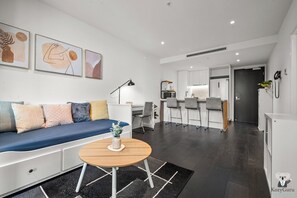 Ein modernes Wohnzimmer mit einer Couch, einem Couchtisch und Kunstwerken an der Wand.