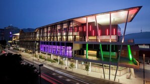 Een modern gebouw met een glazen gevel en kleurrijke verlichting.