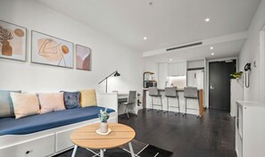 A modern living room with a sofa, a round coffee table, and artwork on the wall.