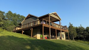A two-story house with a covered deck and a slide. - Spacious Seneca Lake Retreat in the Heart of the Finger Lakes! (Burdett)