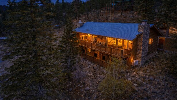A two-story log cabin with a balcony, surrounded by trees. - Beautiful log cabin high above the Rio Ruidoso River. The Log & Order Cabin. (Ruidoso)