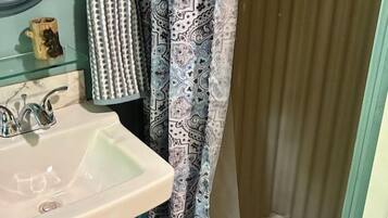 Chuveiro, toalhas de banho, sabonete, papel higiênico