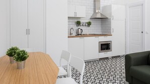 A modern kitchen with white cabinets, a stainless steel range hood, and a patterned floor. - Picasuss Loft Close Beach & Promenade (Málaga)