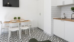 A modern kitchen with white cabinets, a wooden countertop, and a tiled backsplash. - Picasuss Loft Close Beach & Promenade (Málaga)