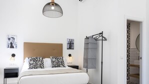 A modern bedroom with a large bed, a headboard, bedside tables, a floor lamp, and a patterned floor. - Picasuss Loft Close Beach & Promenade (Málaga)