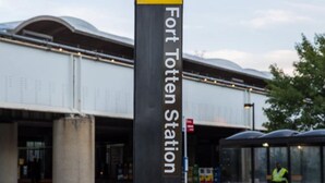A sign for Fort Totten Station with a clear view of the station entrance and a bus stop shelter.