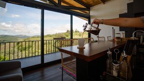 A kitchen with a large window overlooking a scenic landscape.