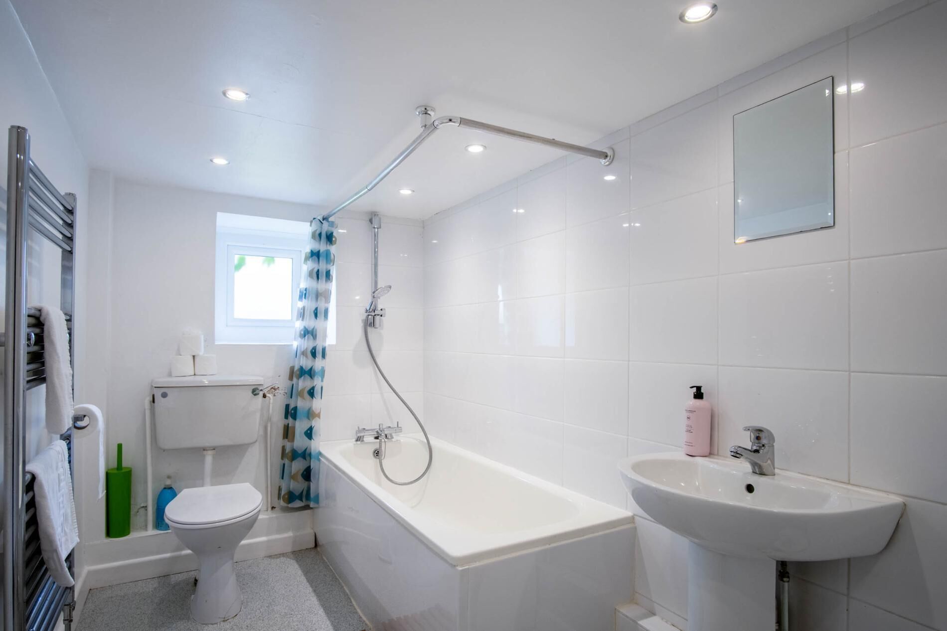 A modern bathroom with a toilet, bathtub, and sink.