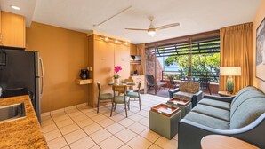 Ein modernes Hotelzimmer mit Küchenzeile, Essbereich, einer Couch und einem Balkon mit Blick.