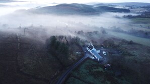 An aerial view of a rural area with a house surrounded by fields and hills. - Lovingly restored 19th-century Bluestack Mountain farm-cottage hideaway (Letterbarrow)