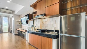 Een moderne keuken met houten kastjes, een roestvrijstalen koelkast en een inbouwoven.