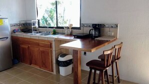 A compact kitchen with a refrigerator, sink, and wooden counter. - Lindora Ranch (Monteverde)