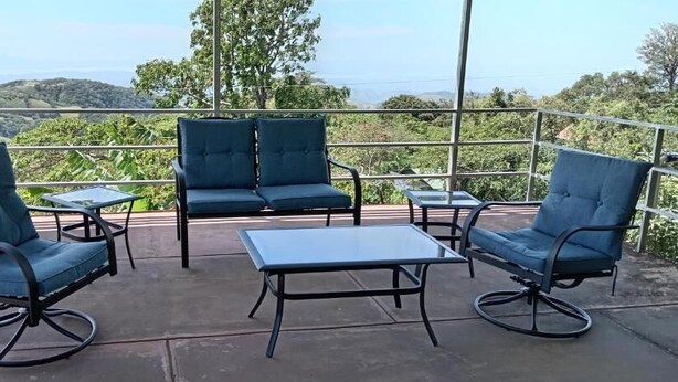A terrace with a view of hills, featuring a sofa set and a table. - Lindora Ranch (Monteverde)