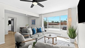 A modern living room with a grey sofa, a coffee table, and a ceiling fan.
