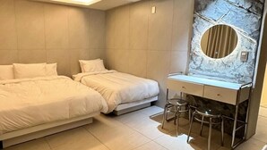 A modern bedroom with two beds, a vanity with a mirror, and a tiled floor. - song stay (Dangjin)