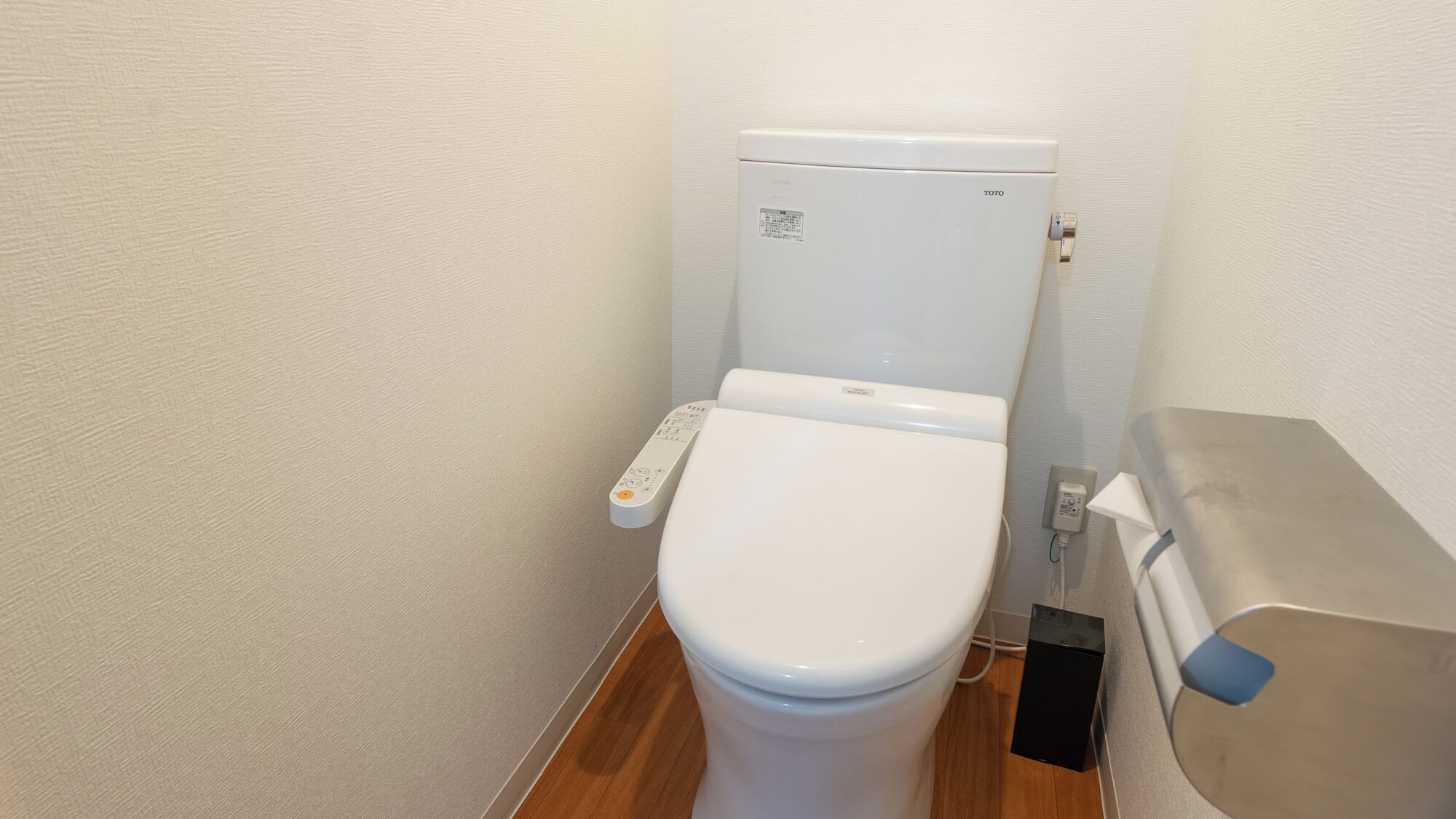 Een wit toilet met bedieningspaneel en een douchetoilet.