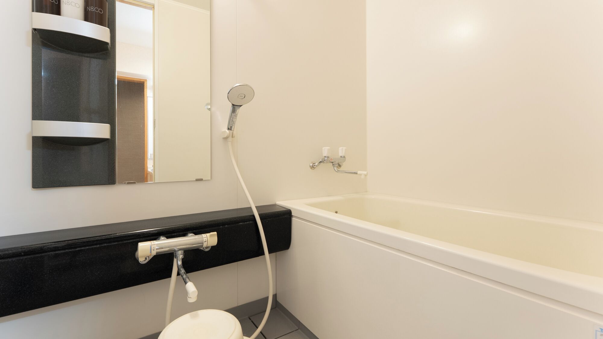 Un baño con bañera, inodoro, lavabo y espejo.