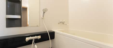 Un baño con bañera, inodoro, lavabo y espejo.