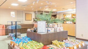 Mostrador de aperitivos con diferentes productos empaquetados y un menú de la tienda.