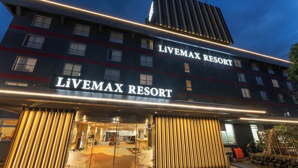 Exterior del Livemax Resort, con señalización iluminada y un diseño arquitectónico moderno.