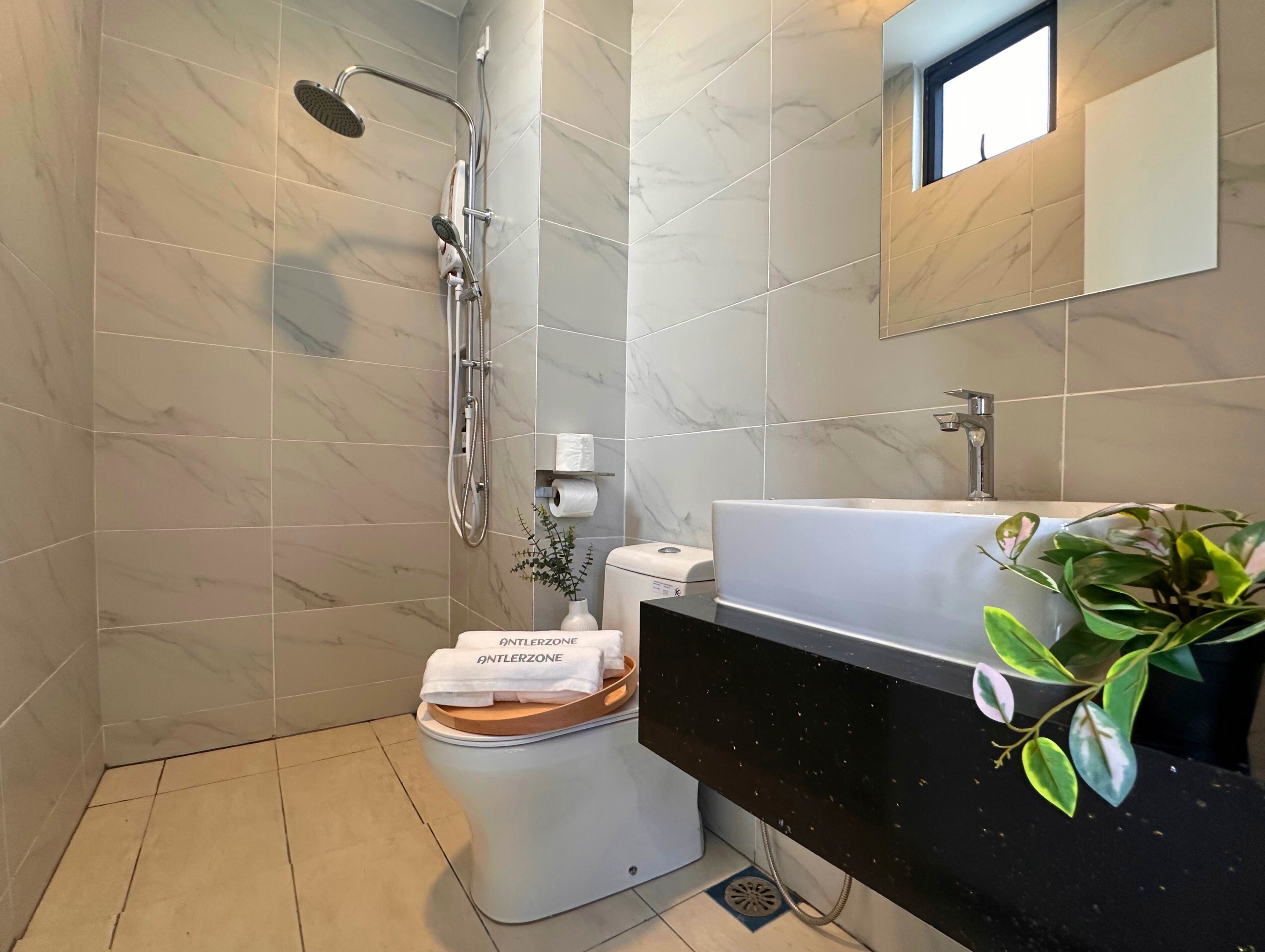 A modern bathroom with a shower, toilet, and sink.