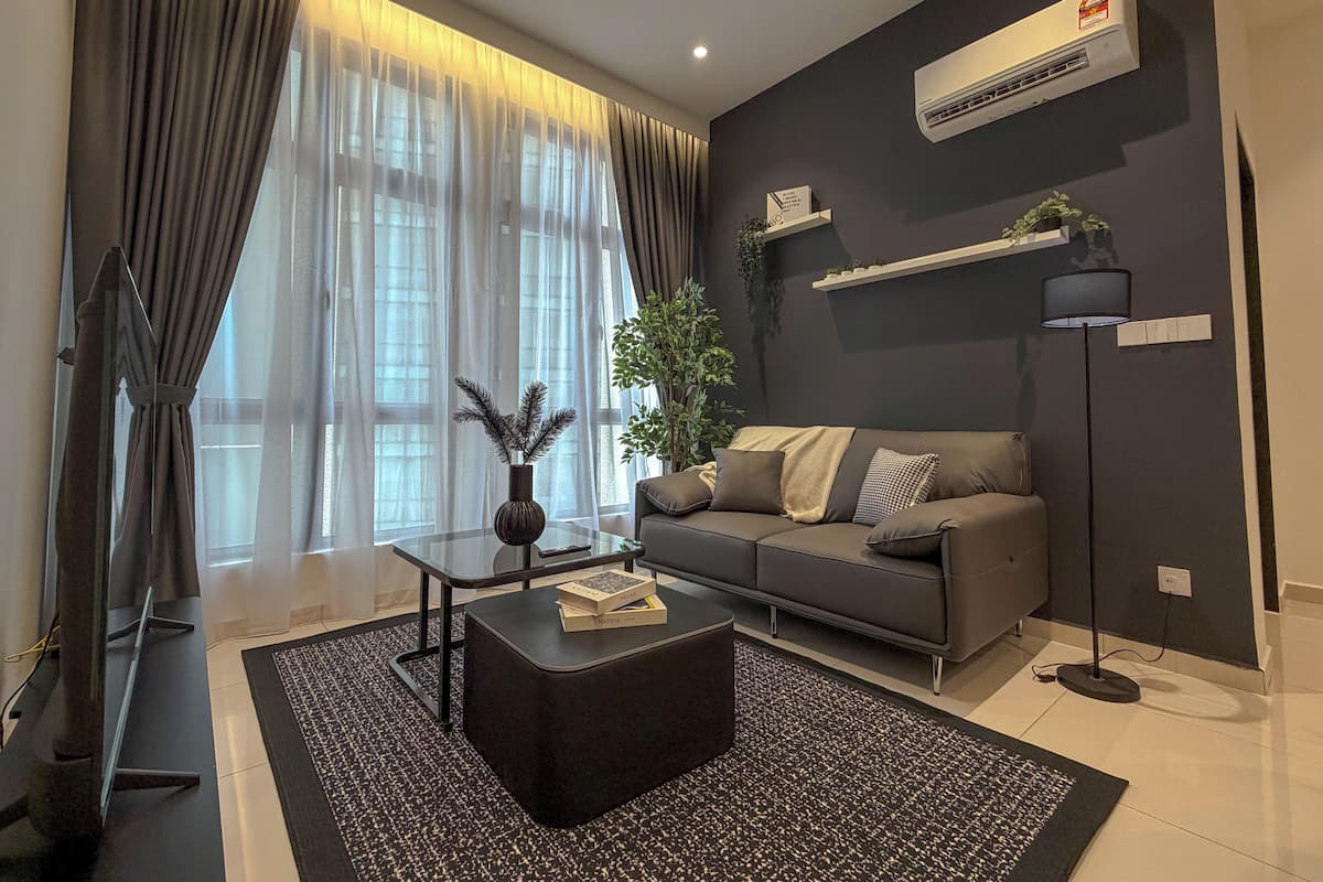 Un salon moderne avec un canapé, une table basse et un téléviseur.