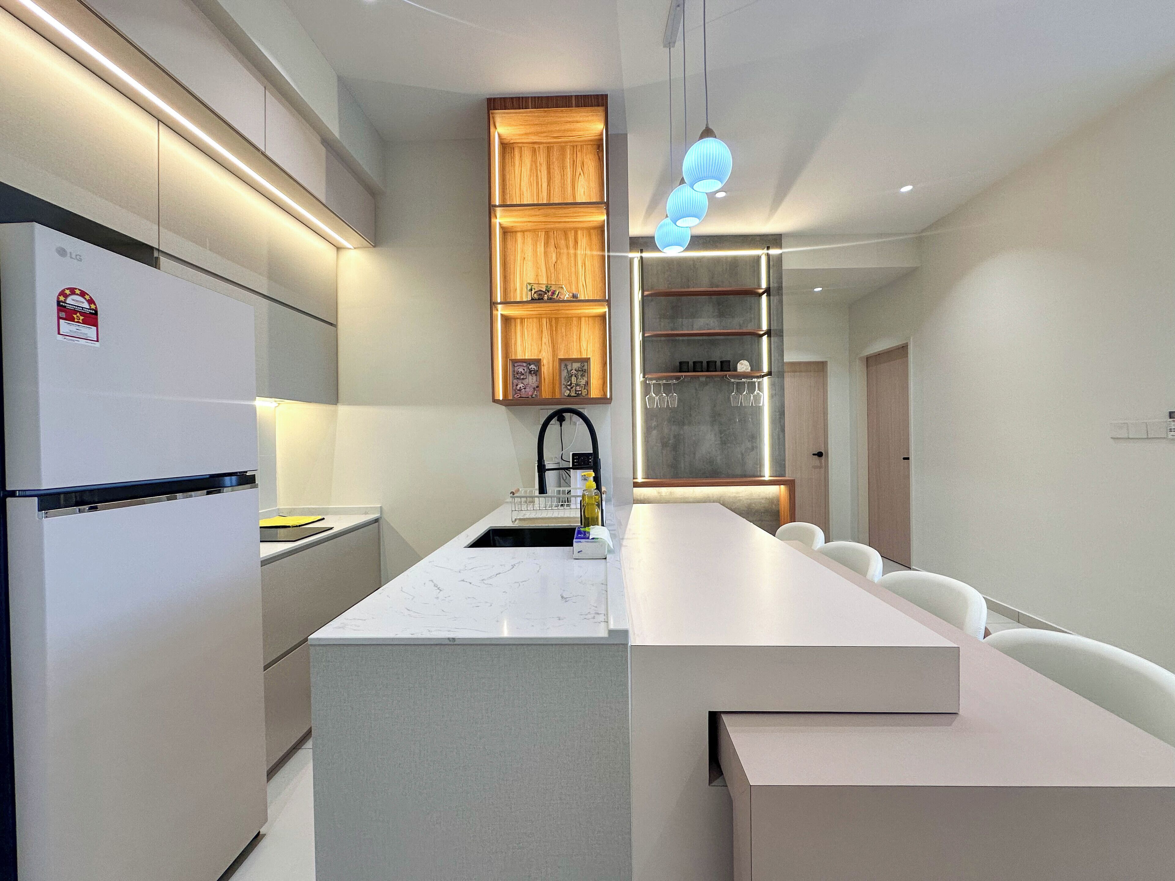 A modern kitchen with a built-in island, white cabinetry, and a stainless steel range hood.