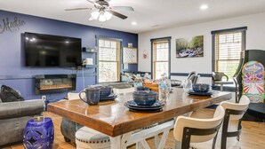 A dining area with a wooden table, chairs, and a television mounted on the wall.
