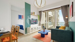 A modern living room with a sofa, a dining table, and a TV. - Kawari by Kozystay - Paskal (Bandung)