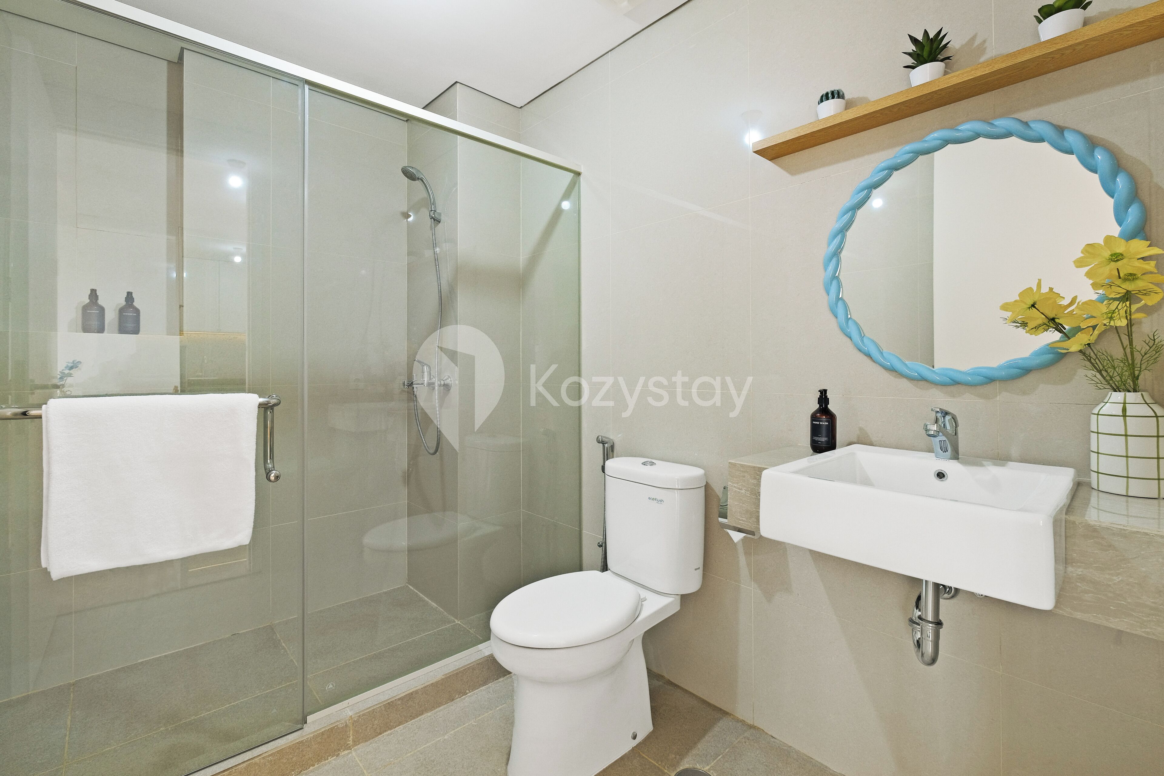 A modern bathroom with a glass-enclosed shower, a white toilet, and a sink with a mirror.