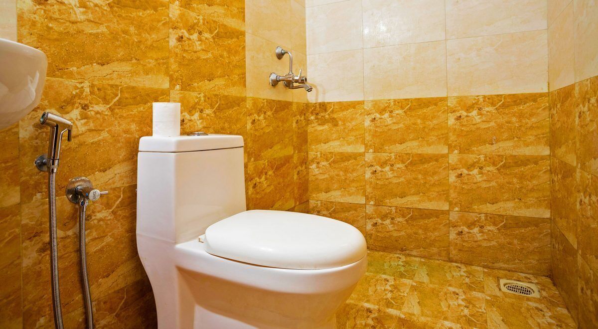 A bathroom with a toilet, a shower, and a sink.