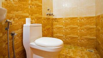 A bathroom with a toilet, a shower, and a sink.