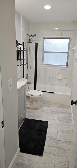 Een douche, handdoeken, zeep, toiletpapier