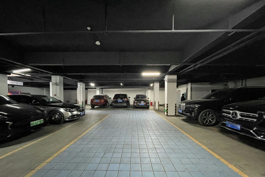 A multi-level underground parking garage with several cars parked.