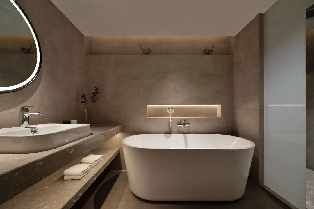 A modern bathroom with a freestanding bathtub, a double sink vanity, and a large mirror.
