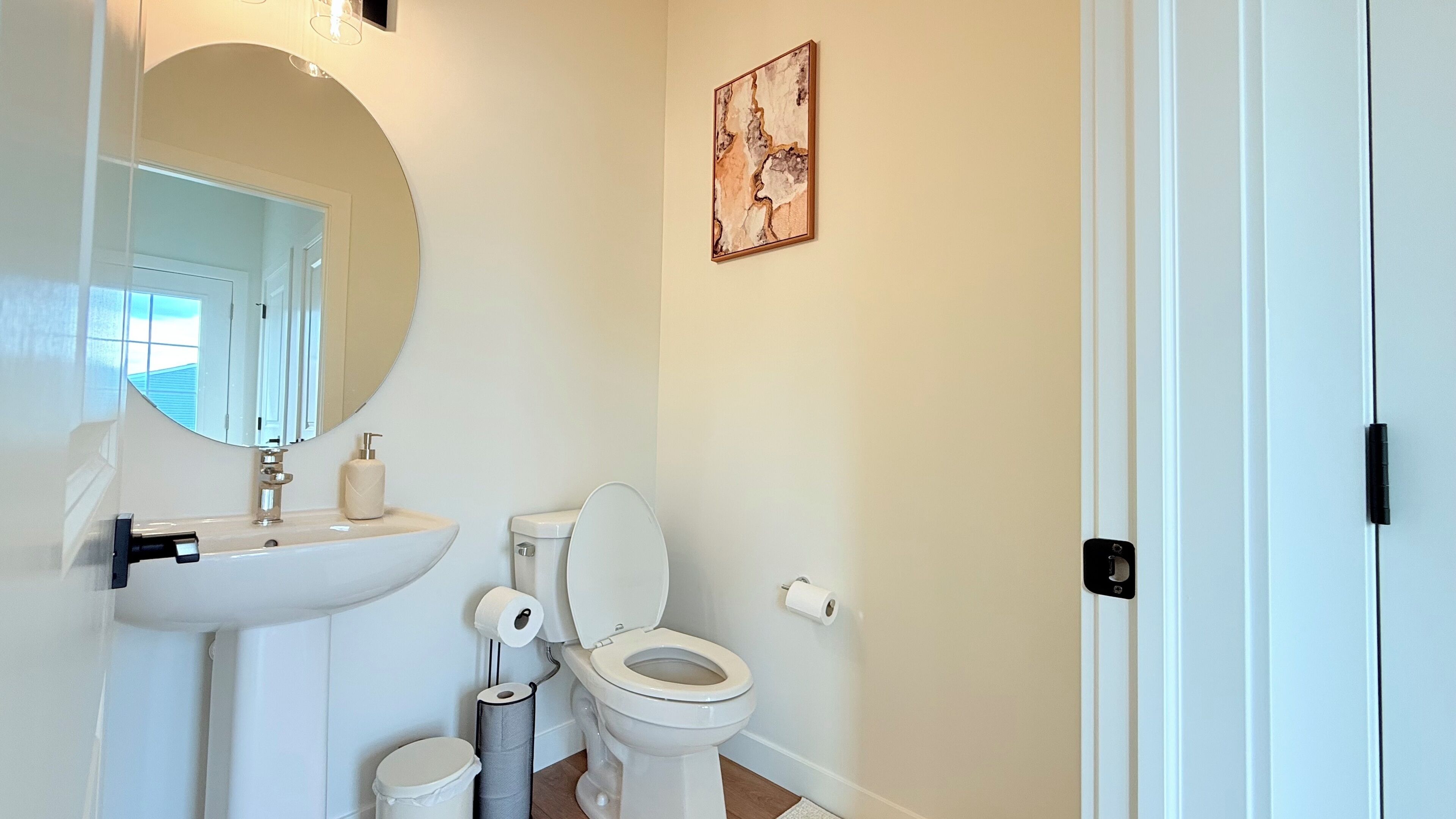 Een badkamer met een wastafel, toilet en spiegel.