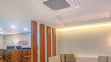 A reception area with a marble counter, wooden slats, and a reception desk.