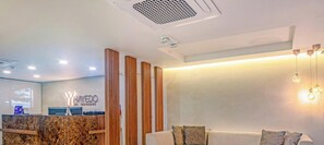 A reception area with a marble counter, wooden slats, and a reception desk. - Edificio Hayedo (Cali)