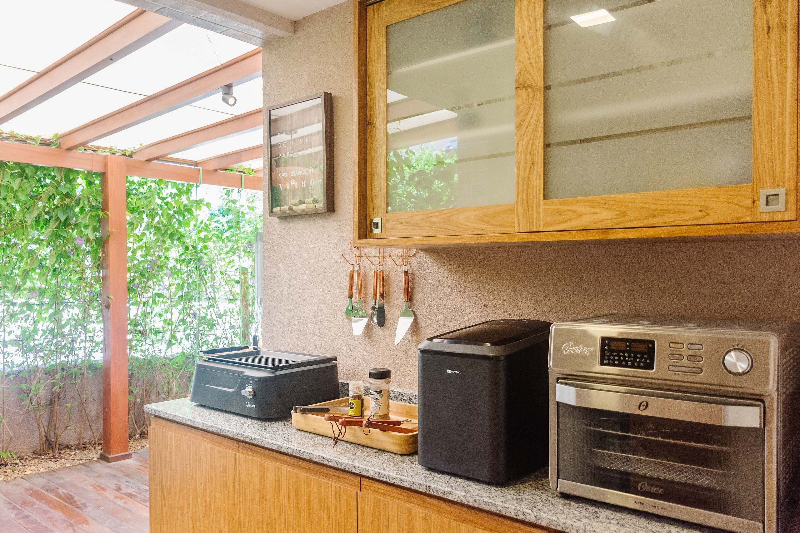 A kitchen with a built-in oven, a coffee maker, and a small refrigerator.