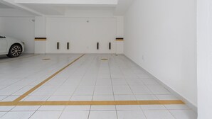 Eine Tiefgarage mit weißen Fliesenböden und gelben Linien, die Parkplätze abgrenzen.