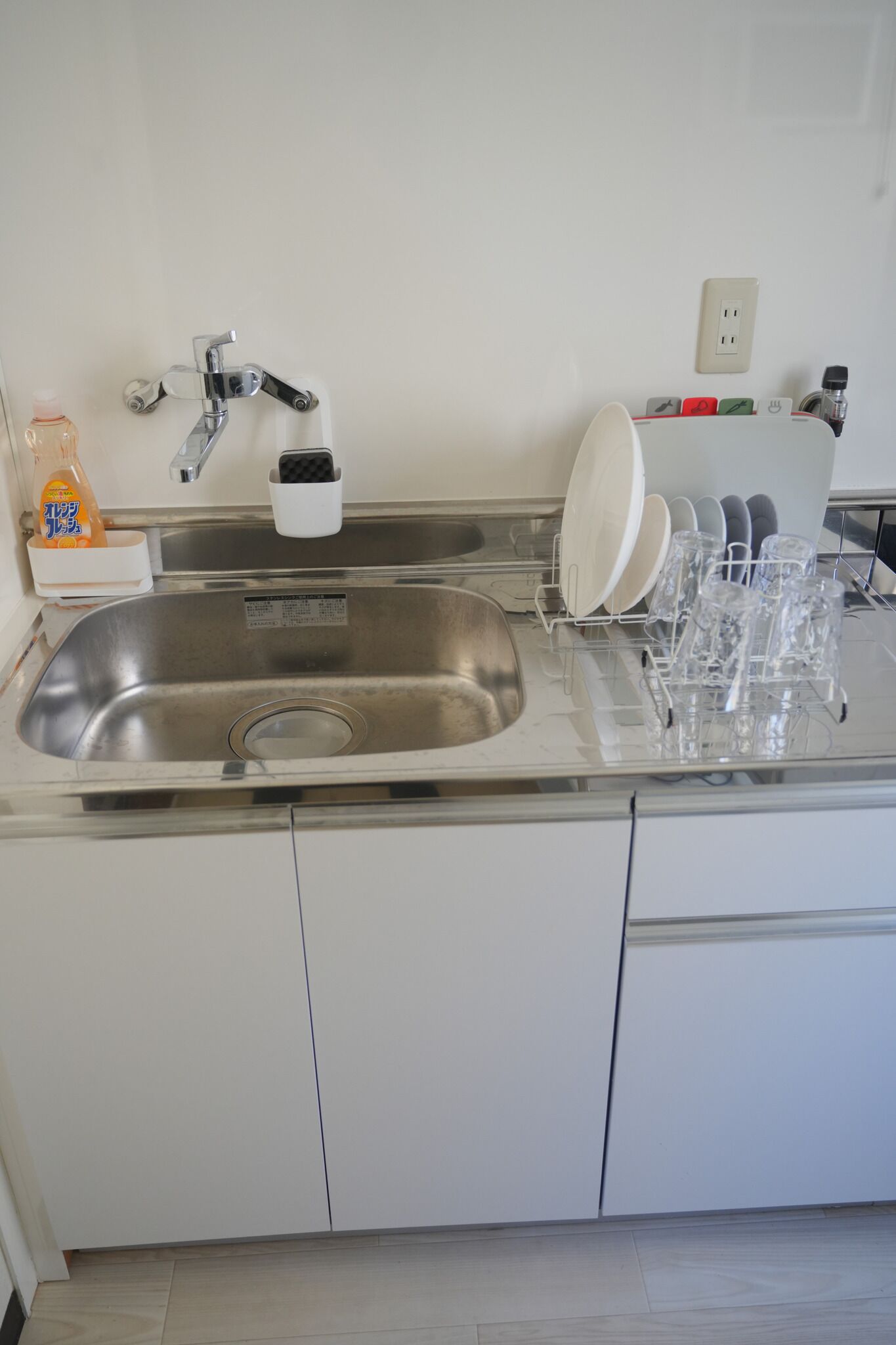 Een koelkast, een magnetron, een kookplaat, kookgerei, borden en bestek