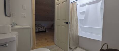 A bathroom with a toilet, sink, and shower area.